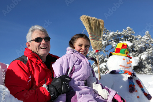 Photo: Father and daughter making a snowman Father and daughter making a snowman