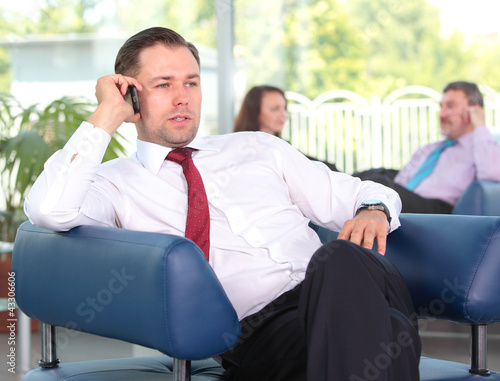 Photo: Young business man enjoying a conversation over cellphone Young business man enjoying a conversation over cellphone