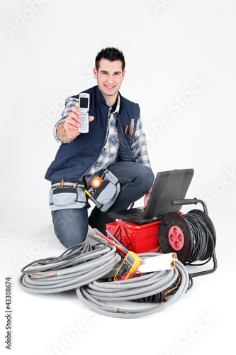 Photo: Happy electrician showing cellphone Happy electrician showing cellphone