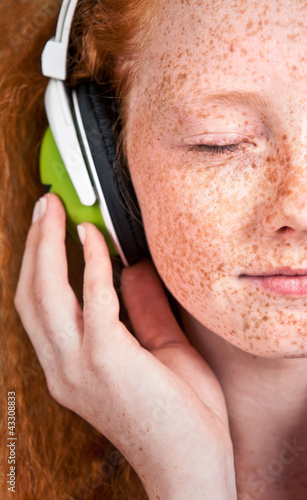 Photo: Portrait of a young woman listening to music with headphones Portrait of a young woman listening to music with headphones