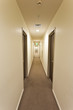 Long corridor with hotel room doors and exit sign