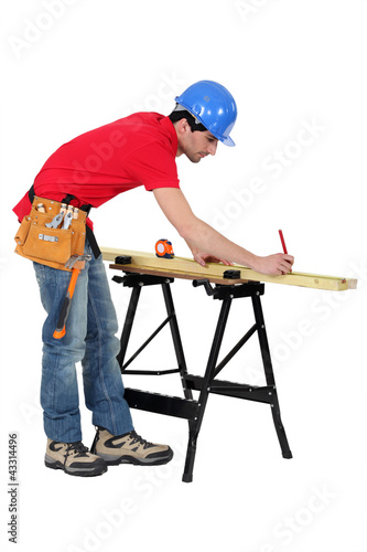 Foto: Carpenter marking a piece of wood Carpenter marking a piece of wood