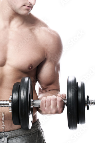 Photo: Muscular guy doing exercises with dumbbells Muscular guy doing exercises with dumbbells