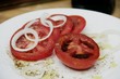 Tomatenscheiben mit Zwiebelringen