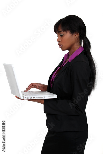 Photo: attractive black woman using laptop isolated on white attractive black woman using laptop isolated on white