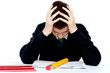 Confused student holding his head in classroom
