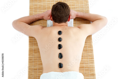 Foto: Man receiving hot stone therapy massage Man receiving hot stone therapy massage