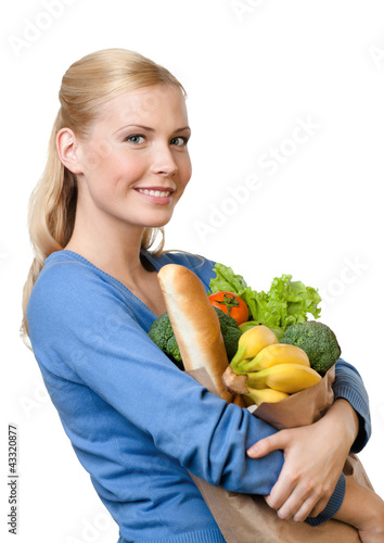 Photo: Beautiful woman with a paper bag full of healthy food Beautiful woman with a paper bag full of healthy food
