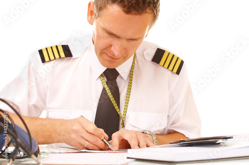 Photo: Airline pilot filling in papers Airline pilot filling in papers