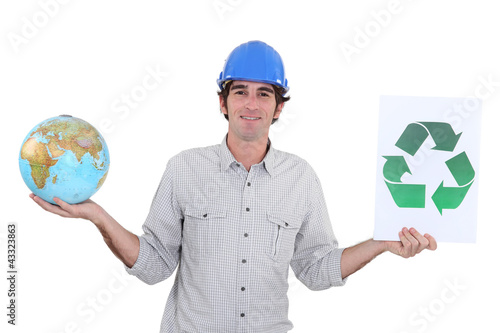 Photo: Construction worker holding a globe and recycle sign Construction worker holding a globe and recycle sign
