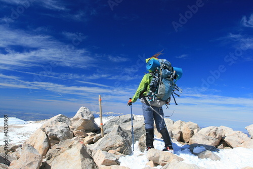 Foto: Woman with backpack on top of mountain Woman with backpack on top of mountain