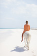 Caucasian woman riding on horseback on beach