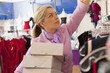 Hispanic business owner carrying boxes in store