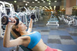 Mixed race woman lifting weights in health club