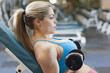 Mixed race woman lifting weights in health club