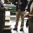 Foreman and workers text messaging on cell phones in factory