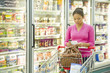 Mixed race woman shopping in frozen food aisle