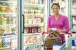 Mixed race woman shopping in frozen food aisle
