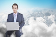 Mixed race businessman using laptop in clouds