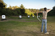 Mixed race archer aiming bow and arrow at target