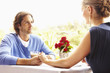 Glamorous Caucasian couple holding hands in restaurant