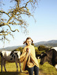 Caucasian teenager standing with cows