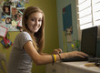 Mixed race teenager using laptop in bedroom
