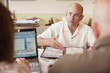 Foto: Caucasian restaurant owner working with co-workers in booth Caucasian restaurant owner working with co-workers in booth