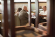 Caucasian restaurant owner working with co-workers in booth