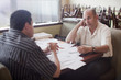 Caucasian restaurant owner working with co-worker in booth