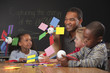 Teacher and children making paper wind turbines in classroom