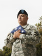 Hispanic soldier holding folded American flag