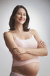 Pregnant Caucasian woman standing with arms crossed
