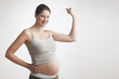 Pregnant Caucasian woman flexing muscles