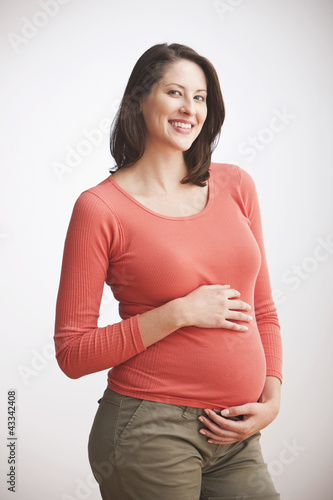 Photo: Pregnant Caucasian woman holding her stomach Pregnant Caucasian woman holding her stomach