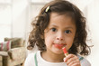 Hispanic girl putting on lipstick
