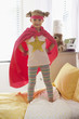 Caucasian girl dressed as superhero playing on bed
