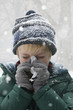 Caucasian boy blowing nose in snow
