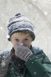 Caucasian boy blowing nose in snow