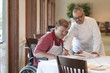 Photo: Chef going over paperwork with worker in wheelchair Chef going over paperwork with worker in wheelchair