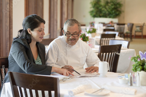 Photo: Hispanic business owner talking to restaurant chef Hispanic business owner talking to restaurant chef