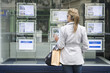 Hispanic woman looking at real estate sign