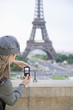Hispanic woman taking photograph of the Eiffel Tower