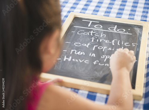 Photo: Korean girl writing to do list on blackboard Korean girl writing to do list on blackboard