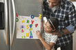 Father looking at daughter's artwork on refrigerator