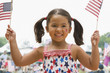 Caucasian girl waving American flags