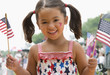 Caucasian girl waving American flags