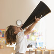 Mixed race boy shouting into megaphone