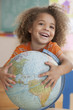Mixed race boy holding globe