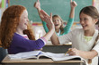 Students high-fiving in classroom